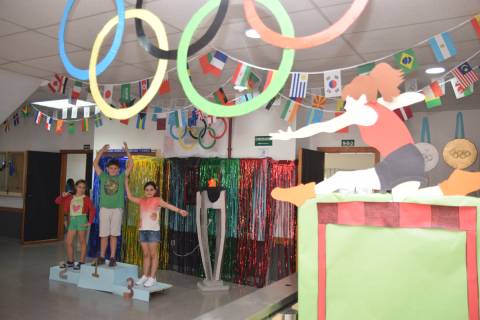 Tres alumnos de UPCTcole en el podio olímpico con el que está decorado el aulario donde se desarrolla la escuela de verano.
