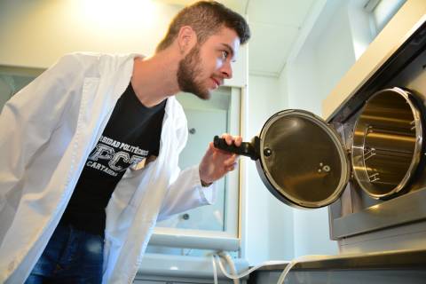 Un estudiante observando un aparato esterilizador del Instituto de Biotecnología Vegetal de la UPCT.