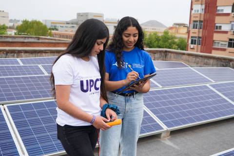 Alumnas en un edificio con placas solares del campus de Alfonso XIII.