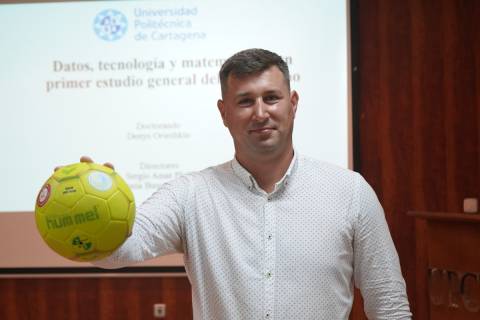 Denys Orieshkin sosteniendo una pelota de balonmano antes de defender su tesis.