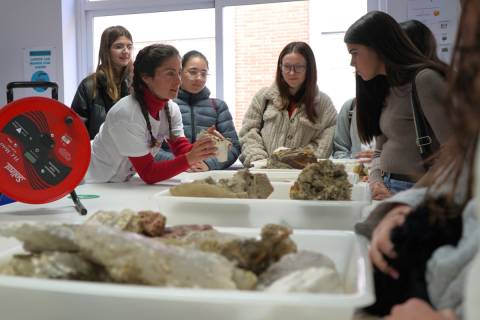 Una investigadora de la UPCT explicando parte de su trabajo a alumnas de Secundaria y Bachillerato.