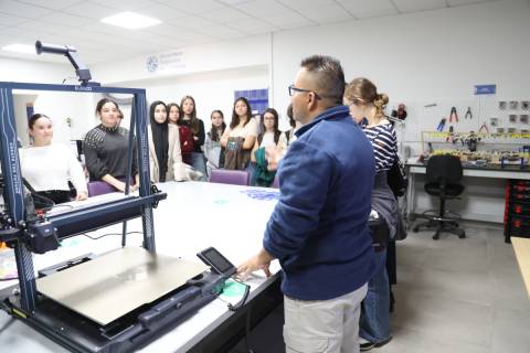 Técnicos del SAIT explican a los preuniversitarios el funcionamiento de una impresora 3D.