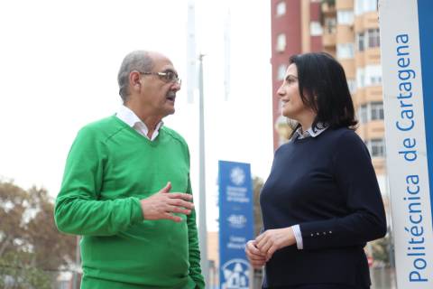 Isidoro y Manuela Guzmán Raja, conversando en un campus de la UPCT. Al fondo, un aerogenerador instalado por una start-up.