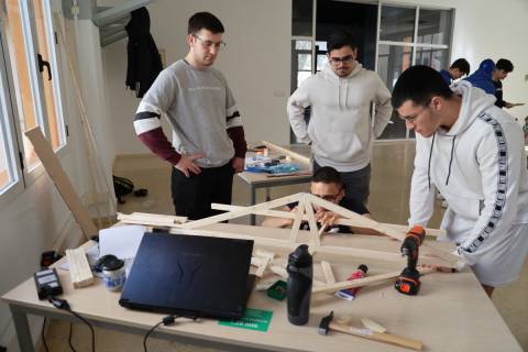 Estudiantes elaborando una maqueta de puente.